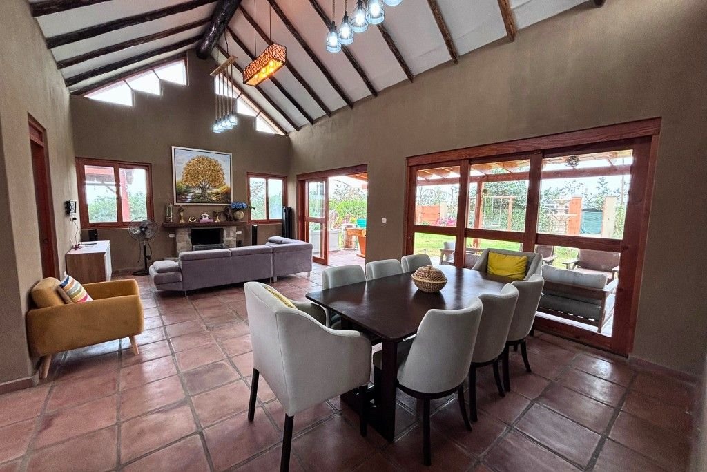 Sala-comedor con chimenea y techos altos con vigas de madera